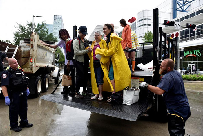 Evacuees Are Unloaded From The Back Of An Open Bed Truck At The George R. Brown Convention Center