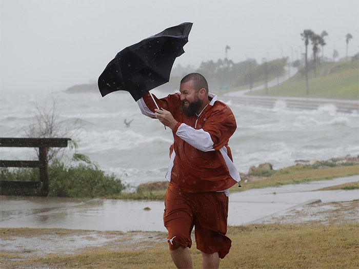 A Man Struggles With His Umbrella As He Tries To Walk In The Wind And Rain On Friday In Corpus Christi, Texas