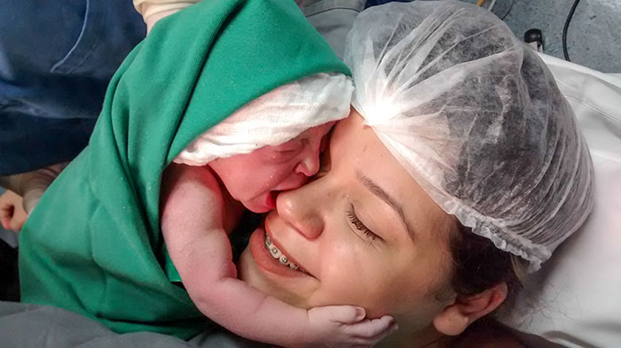 Newborn Girl Clings To Mom’s Face Just Seconds After Birth, And The Video Will Warm Your Heart