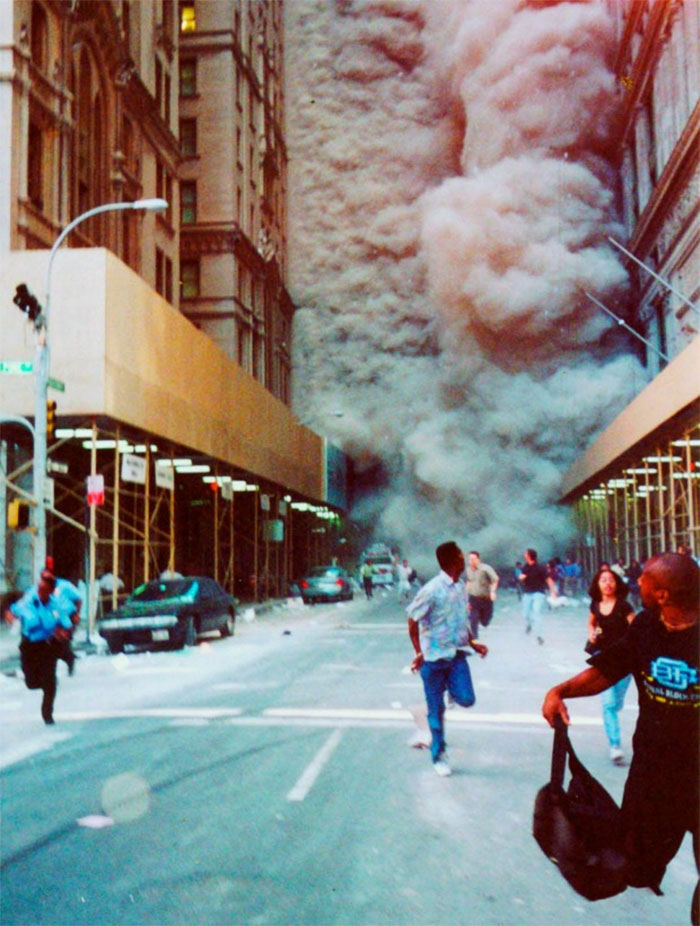 People Run Down Broadway As A Smoke And Dust Cloud Comes Up The Street From The Collapsing World Trade Center Buildings In New York