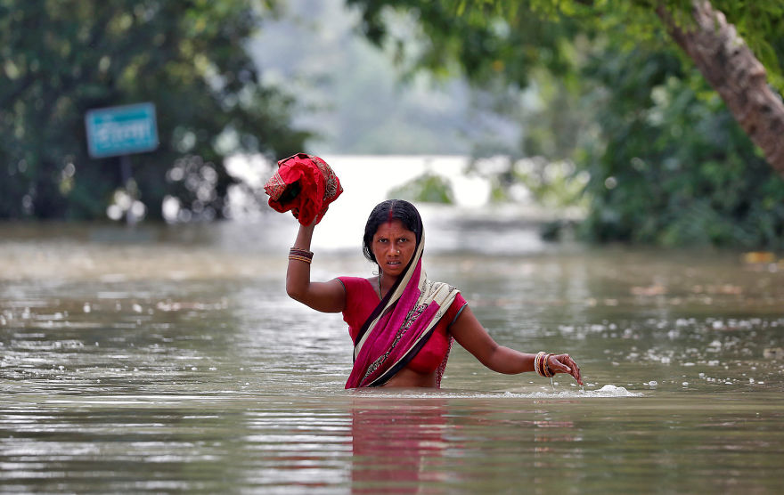 A Woman Wades Through A Flooded Village In Bihar, India