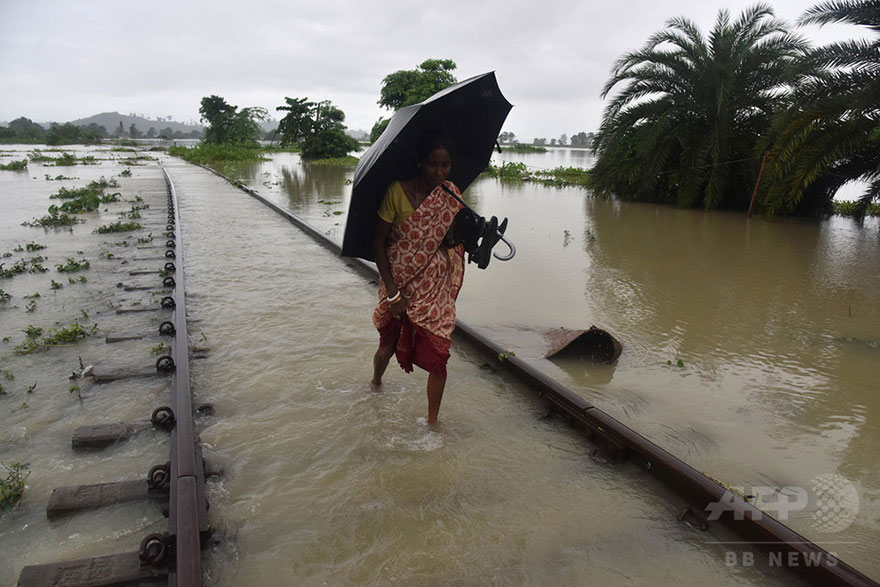 An Indian Villager Walks Along A Submerged Railway Track In The Flood-affected Jakhalabandha Area In Koliabor