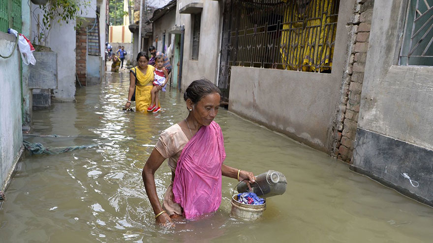Indian Residents Walk Through Flood Waters In Malda In The Indian State Of West Bengal