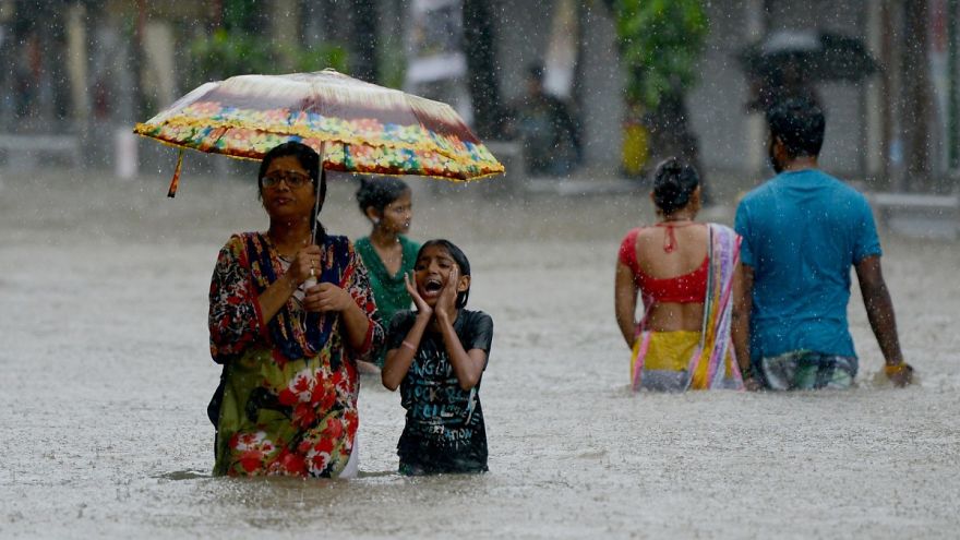 Indians Wade Through A Flooded Street During Heavy Rain Showers In Mumbai