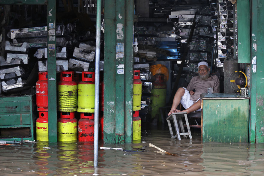 A Bangladeshi Man Sits In His Flooded Shop After Heavy Rain In Dhaka