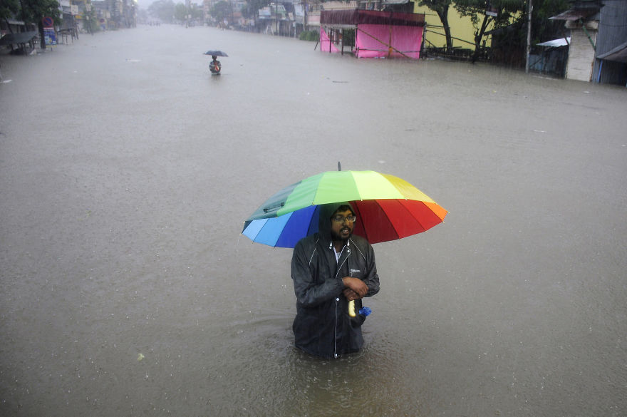 A Man Walks Through A Flooded Street During A Heavy Downpour In The Northeastern Indian State Of Tripura