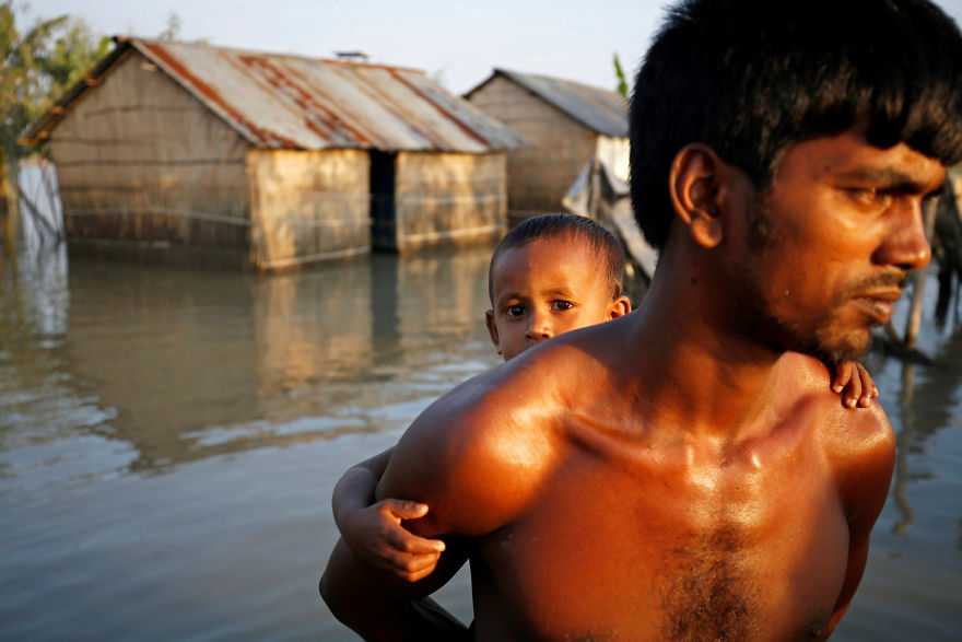 A Child And His Father Walk Through A Flooded Area In Bogra, Bangladesh