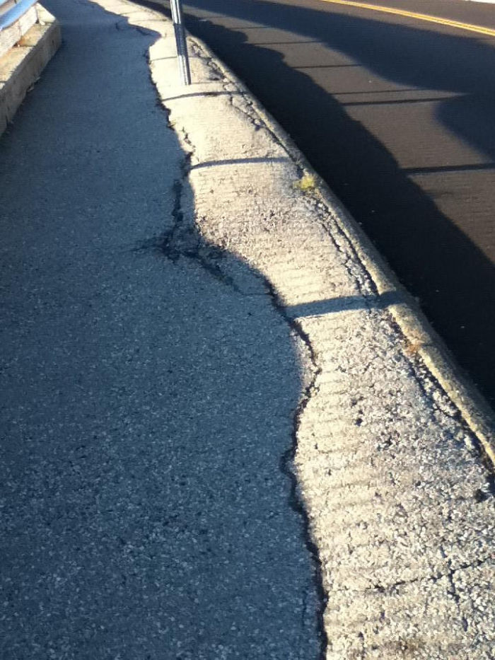 The Shadow Made By The Fence Line Up Perfectly With The Crack In The Concrete