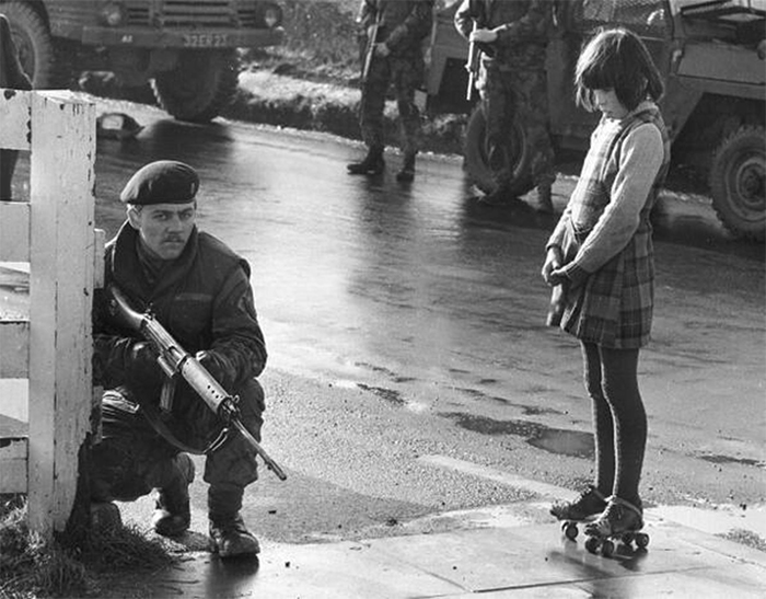 Young Girl With Roller Skates Shows A Soldier In Derry She Isn’t Scared, Northern Ireland, 1969