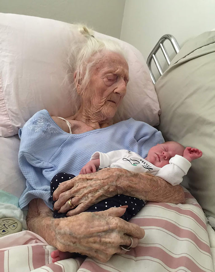 Señora de 101 años sosteniendo a un bebé de 13 días