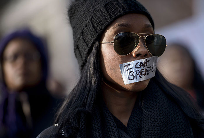 A Woman Listens To A Rally With Her Mouth Taped Shut During The 'Justice For All' March In Washington, Dc, 13 December 2014 