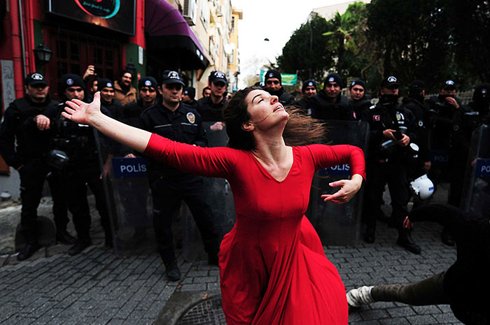 A Woman Dances In Front Of Riot Police During A Demonstration In The Kadikoy Neighborhood Of Istanbul Against The Eviction Of A Squatted Building, 9 December 2014