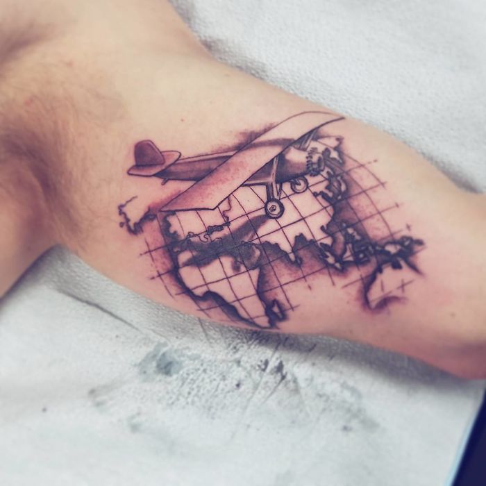 Plane with earth continents arm tattoo