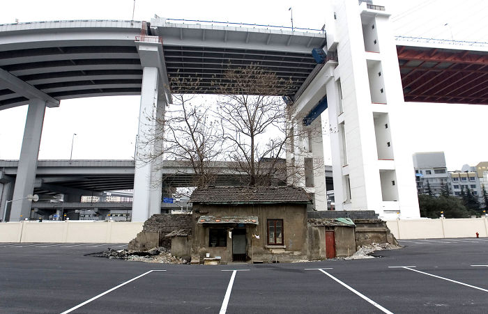 The Last House Of An Old Neighborhood Stands Alone In A Future Shanghai World Expo 2010 Parking Lot, Under Nanpu Bridge On April 6, 2010, In Shanghai, China. The Holdout Owner Of The House Was Shi Yuji. The House Was Destroyed Days Later, And The Owner Moved Into A Workers' Dormitory