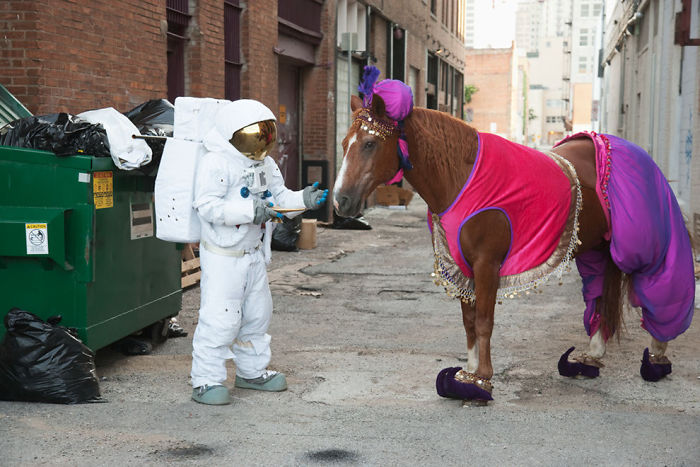 Astronaut asking for wishes from a horse genie in the street near container
