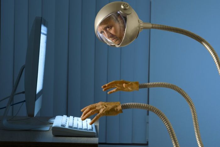 Man like a robot near a computer