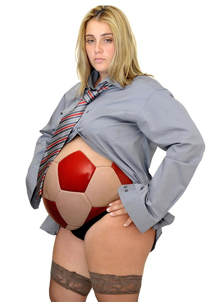 A pregnant blond woman in a gray shirt and her belly is like a football ball
