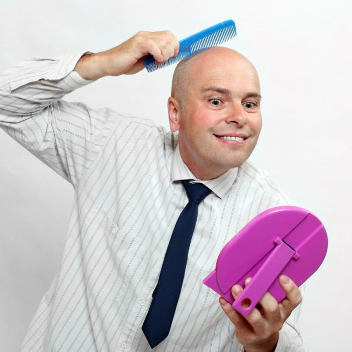 A man in a shirt combing his bald head