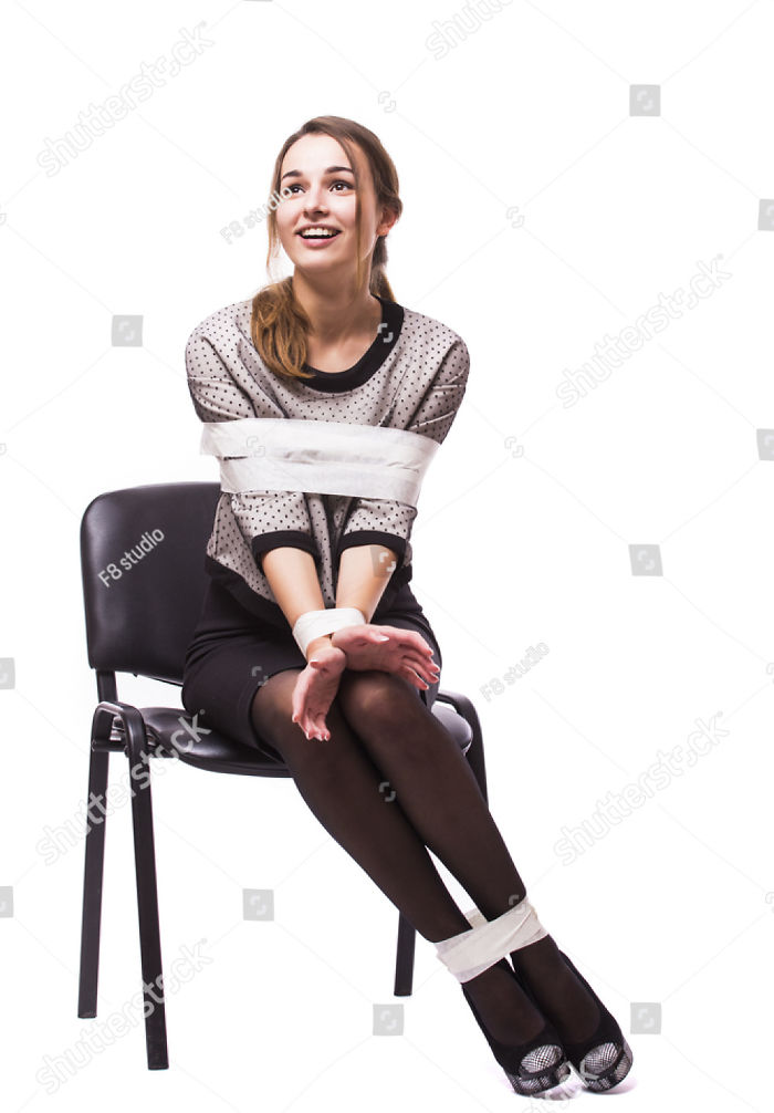 Happy hostage girl with tied hands and legs sitting on a chair