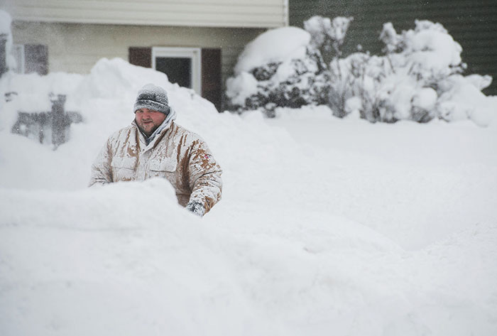 Hombre quitando nieve tras 2 días de nevadas récord en Erie