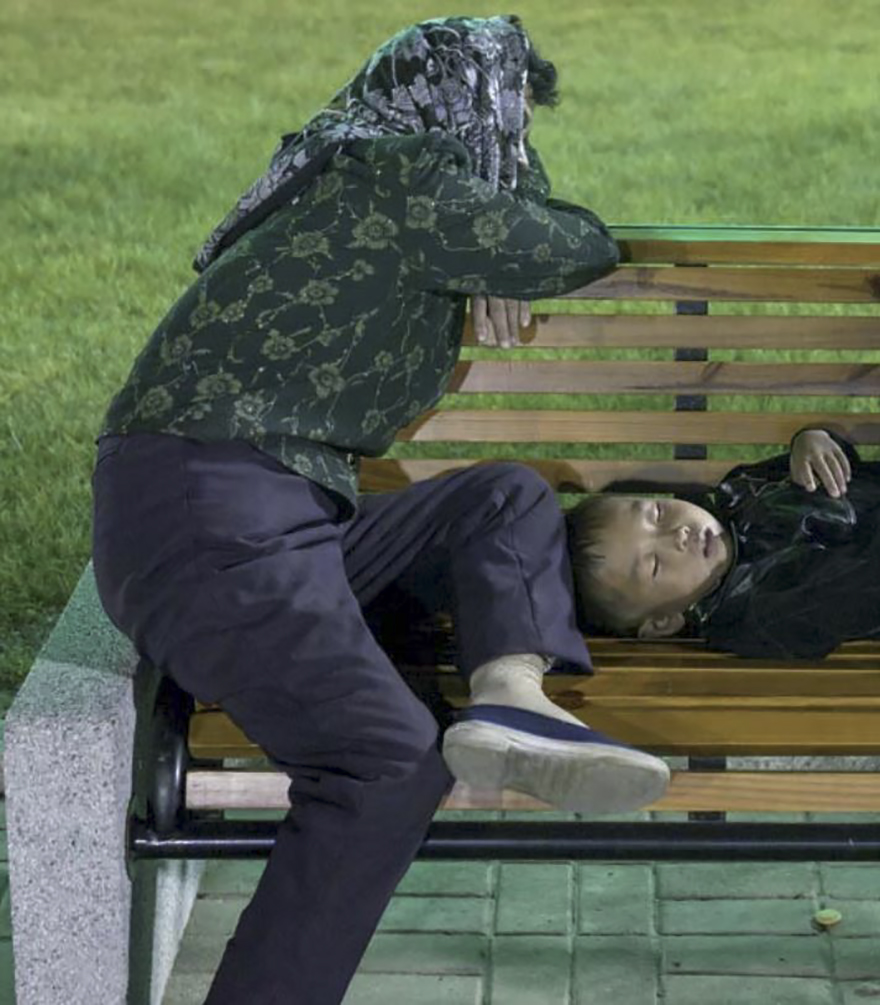 Paranoia Is Too Strong In North Korean Minds. I Took This Picture At A Fun Fair Of A Tired Mother And Child Resting On A Bench. I Was Asked To Delete The Picture Since The Guides Were Certain I Would Have Said Those People Were Homeless