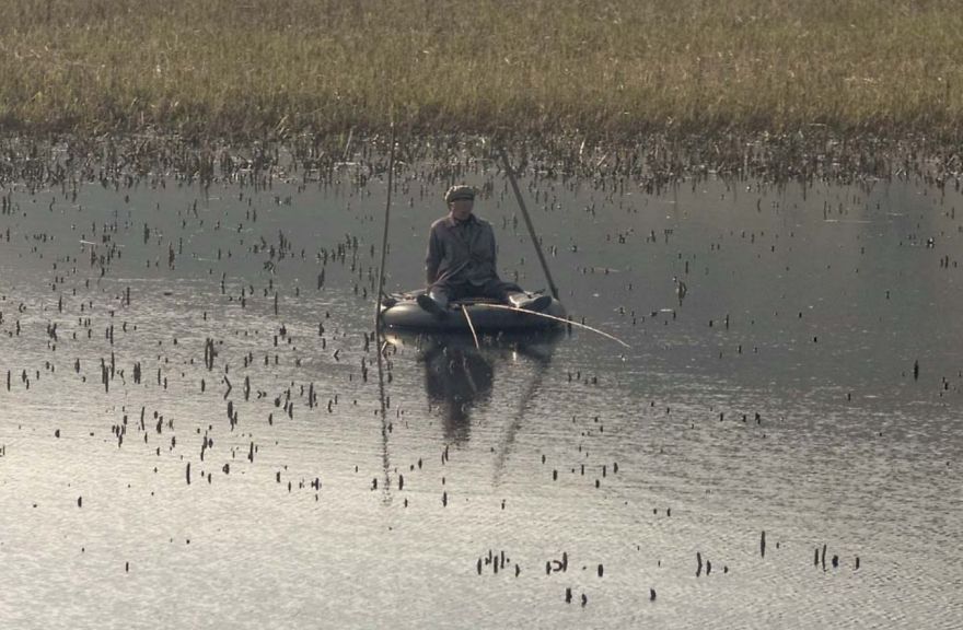 On A Little Lake On The Way To Wonsan, This Fisherman Uses A Tire As A Boat