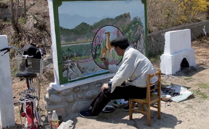 La prohibición más ridícula: este pintor oficial estaba haciendo un mural en Chilbo. Me gritaron al hacer la foto porque el mural no estaba terminado
