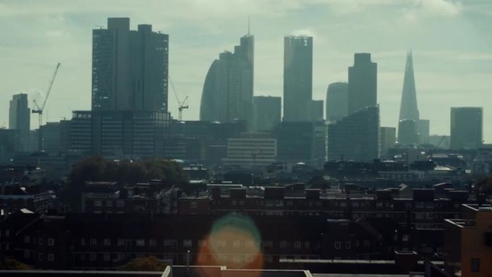 City skyline with modern skyscrapers and cranes under a cloudy sky, showcasing urban development in a thriving metropolis.