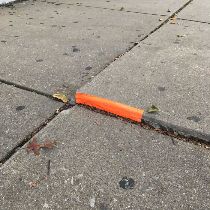 Someone Put Tape On This Raised Bit Of Sidewalk