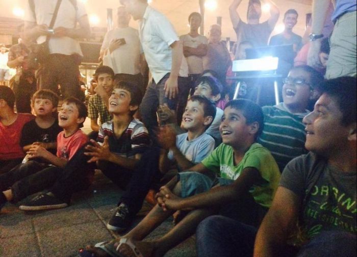 Hungarian Volunteers Put Up A Projector Playing Tom And Jerry For Syrian Refugees