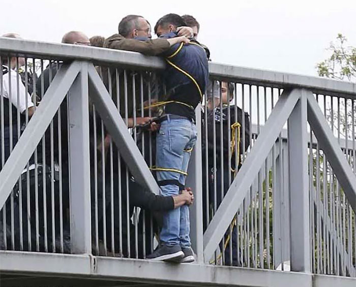 People Holding Onto Man Trying To Commit Suicide