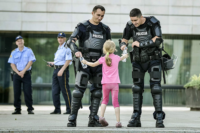 Girl Hands Water To Two Officers During Bosnian Protest
