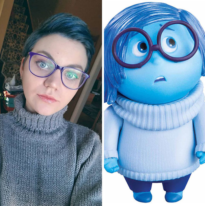 Person with blue hair and glasses accidentally cosplaying a blue cartoon character in a gray sweater.