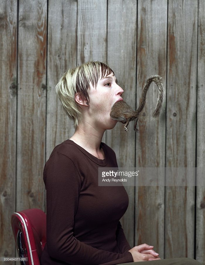 Young woman with squirrel in her mouth