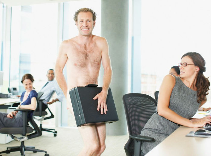 Naked businessman with briefcase in office among workers