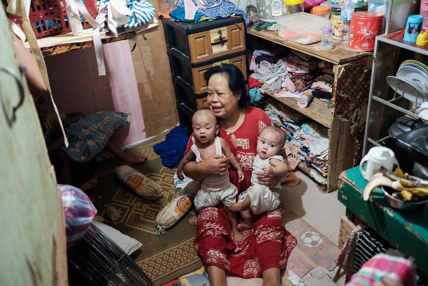 Woman With Her Grandchildren In Their Little Room. 5 People Are Living In This Small Room