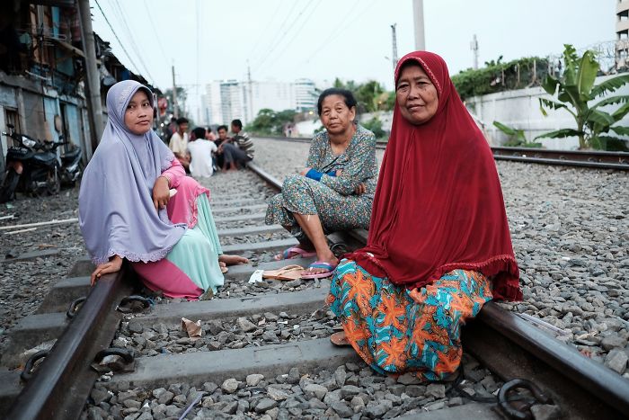 Mujeres sentadas cómodamente en las vías del tren activas