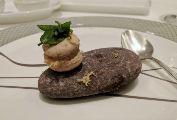 Single Mini Macaron Topped With Basil On A Rock