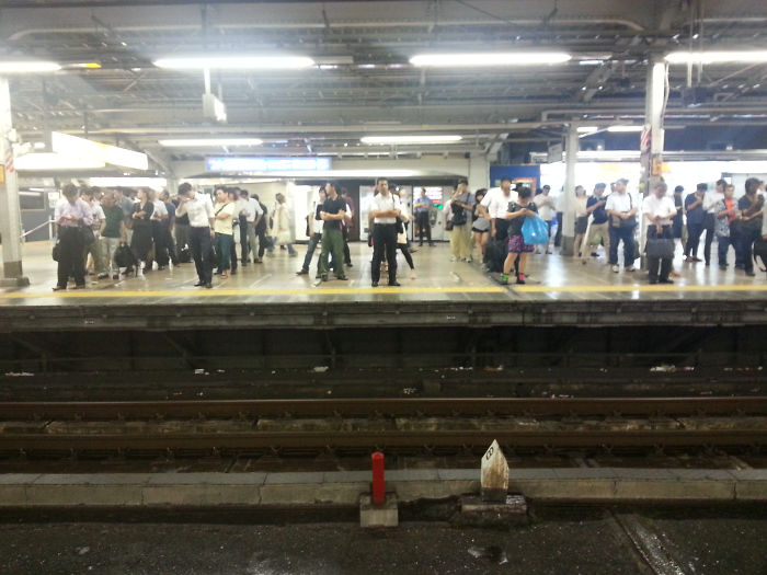 Viajeros colocados esperando el tren en Tokyo