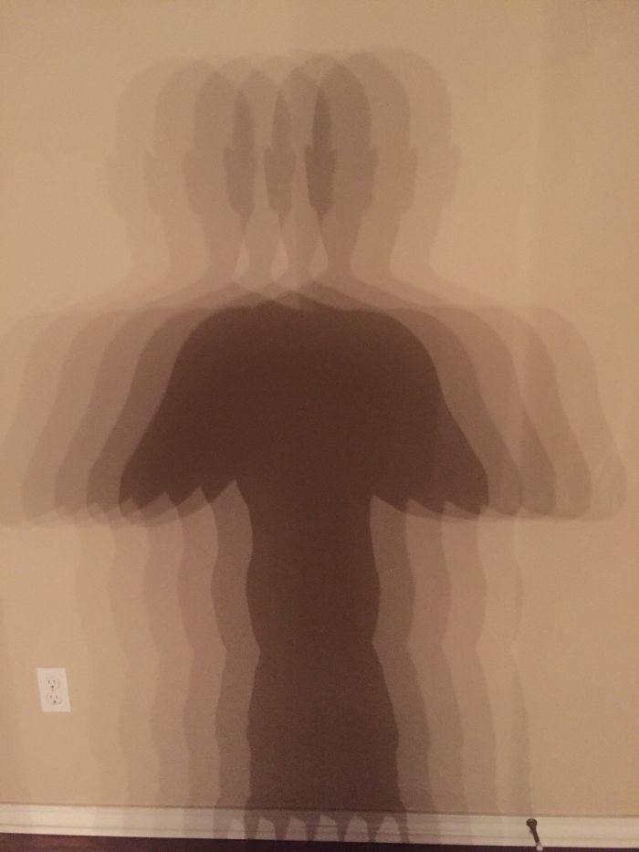 Mi baño tiene 6 bombillas sobre el espejo, esta es mi sombra en la pared de atrás