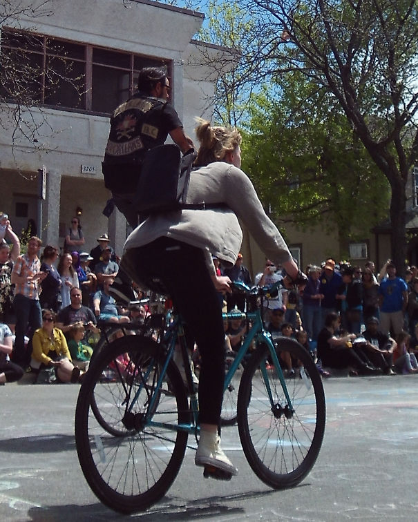 Tiny Man Riding A Woman On A Bicycle