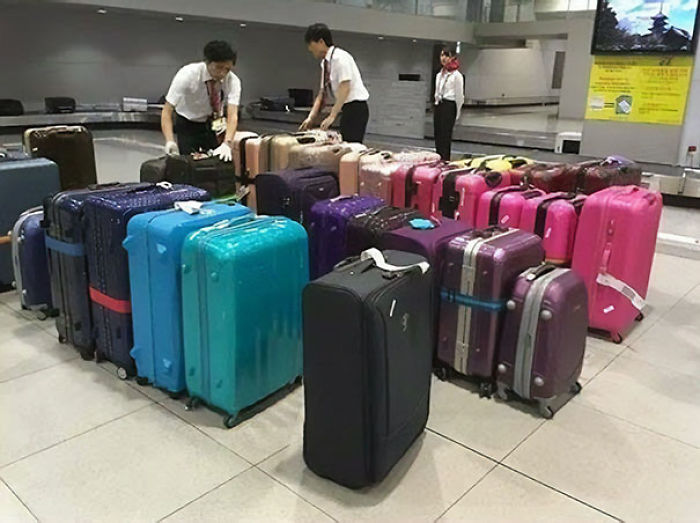 Personal del aeropuerto colocando el equipaje en la cinta por color