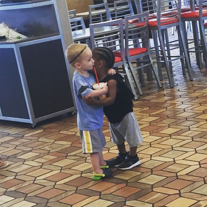 Dos niños desconocidos abrazándose porque si en un restaurante de comida rápida