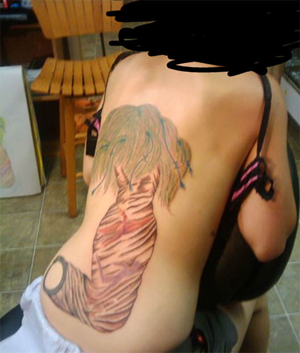Cut arm with wig in hands tattoo on arm