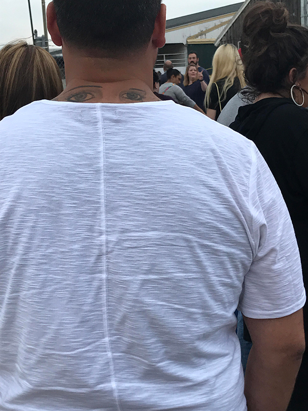 Eyes tattoo on man's back neck