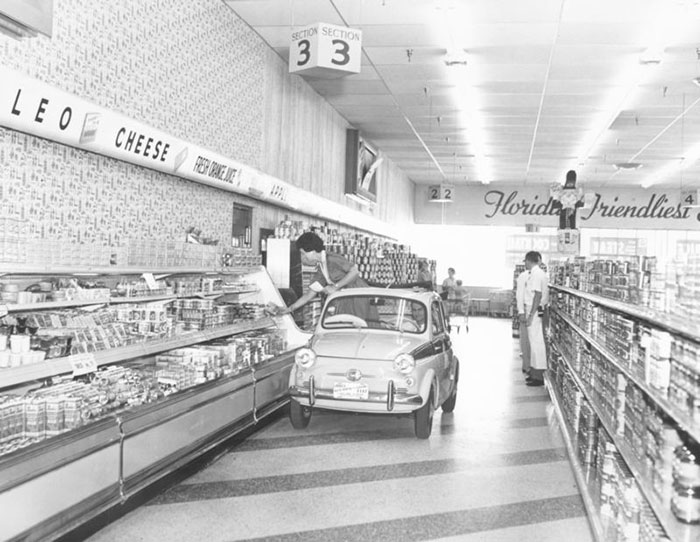 Publix Supermarkets Showcased Their Wide Aisles And A Self-Service Dairy Case By Driving A Shopper Around A New Store In A Tiny Car, Circa 1957