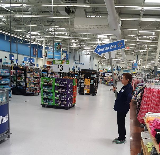 Walmart Worker Carries A Sign Saying "Shorter Line". Couldn't They Just Use Her Behind A Register?