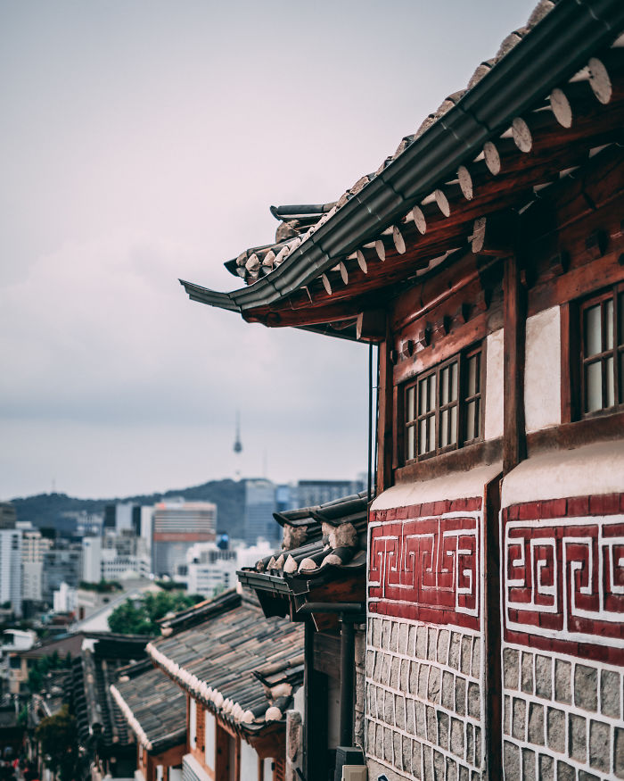 Traditional Korean architecture in Seoul with cityscape and Namsan Seoul Tower in the background, reflecting life as an English teacher.