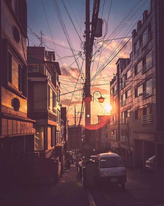 Seoul city street at sunset with power lines and parked cars, captured by an English teacher living in Seoul.