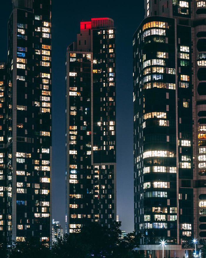 Night view of Seoul city skyscrapers illuminated, showcasing urban high-rise buildings in South Korea's capital.
